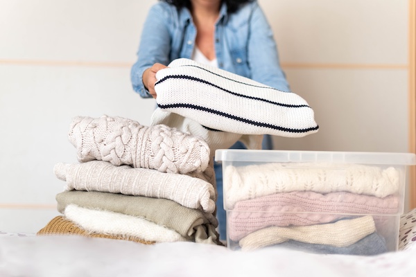 Packing away clothes into plastic boxes to protect from pests